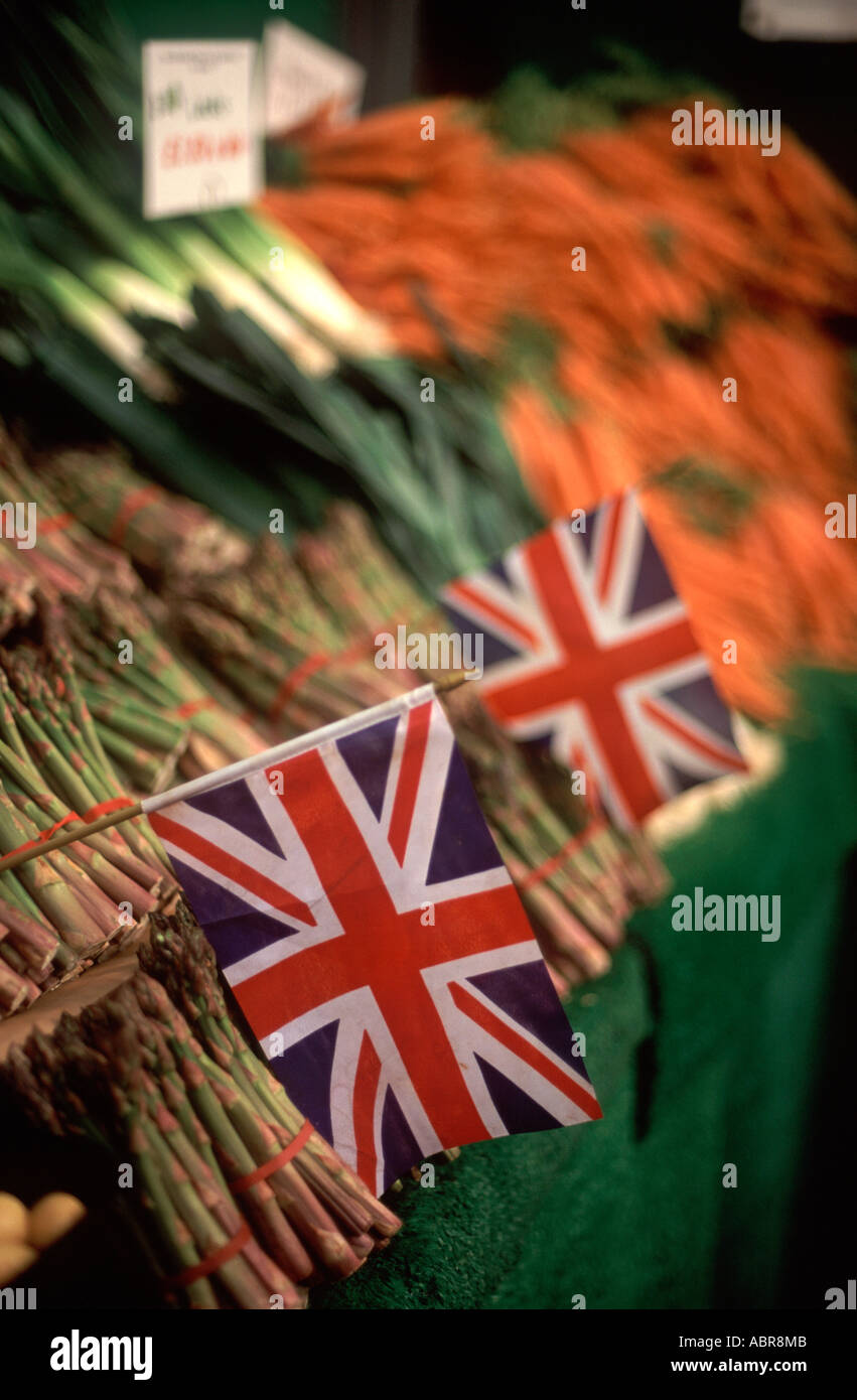 Union Jack flags amongst asparagus, leeks and carrots on display at Borough Market, Southwark, London, England Stock Photo