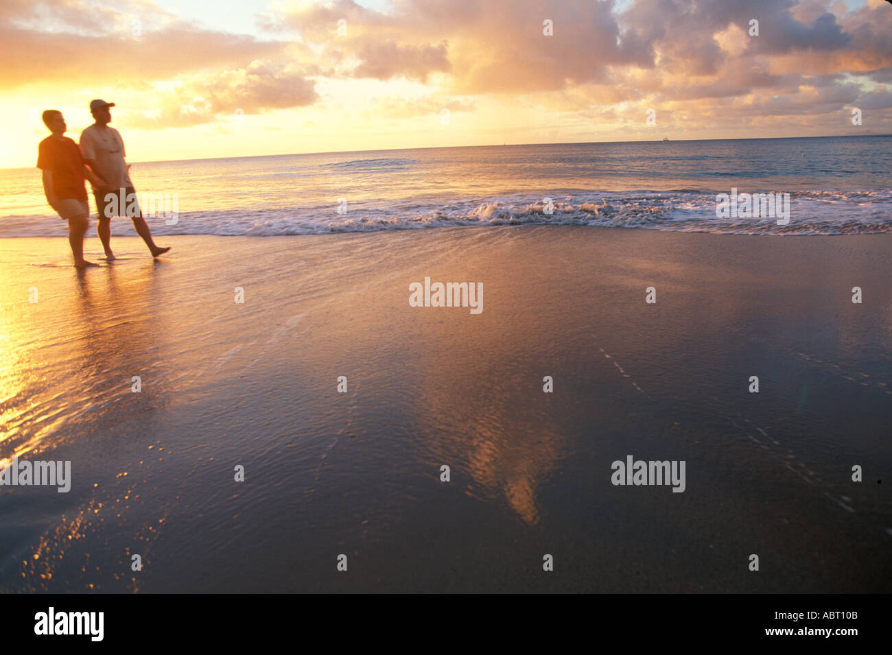Caribbean beach sunset couple walking on beach at sunset Stock Photo