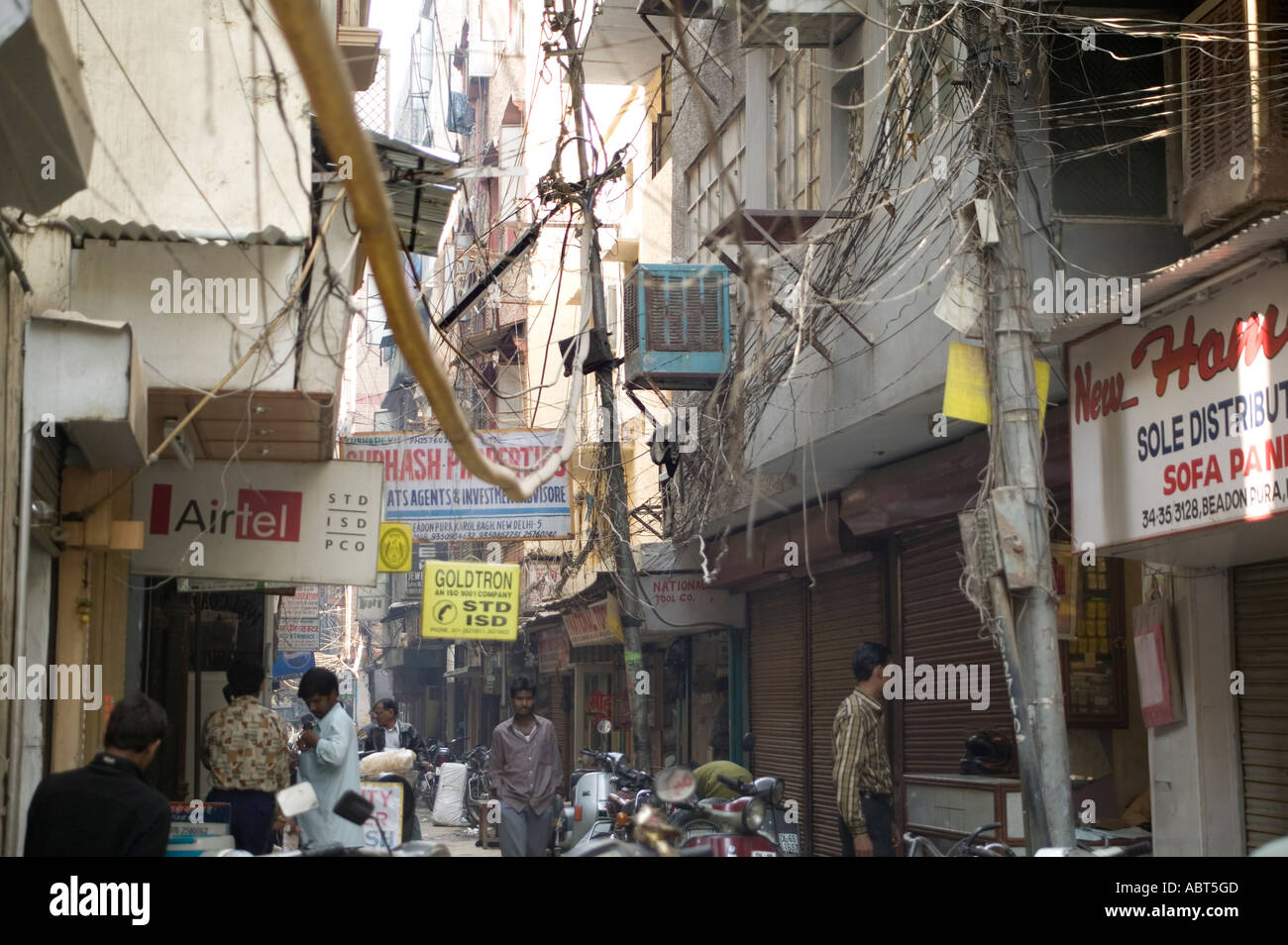 Telephone and power cables litter the skyline of one of Delhi s many alleyways India Stock Photo