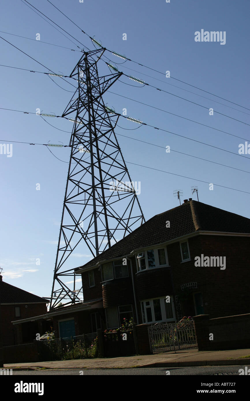 electricity pylon very near a house in a suburban estate Stock Photo