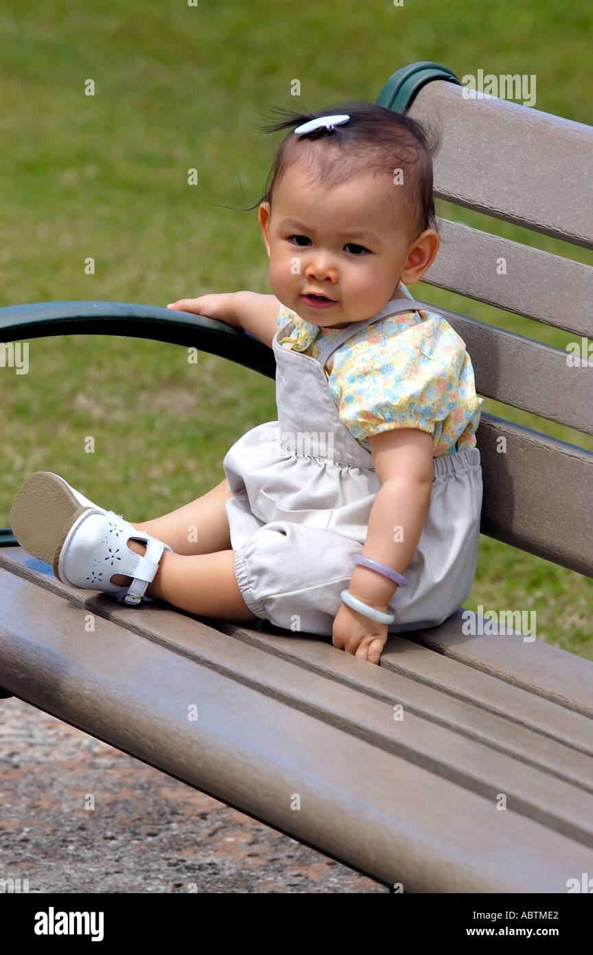 A young girl sitting on a park bench enjoying the outdoors Stock Photo ...