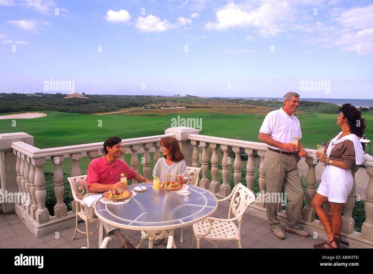 Couple in their 50s enjoying an exclusive country club with drinks after golf Stock Photo