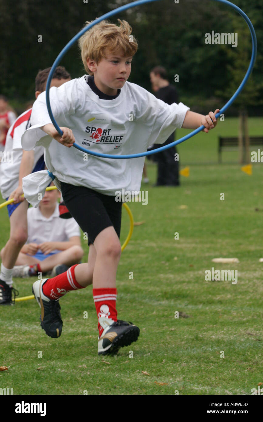 A Junior School Boy Runs With A Hoop During His School Sports Day Clissold Park London Uk Stock Photo Alamy