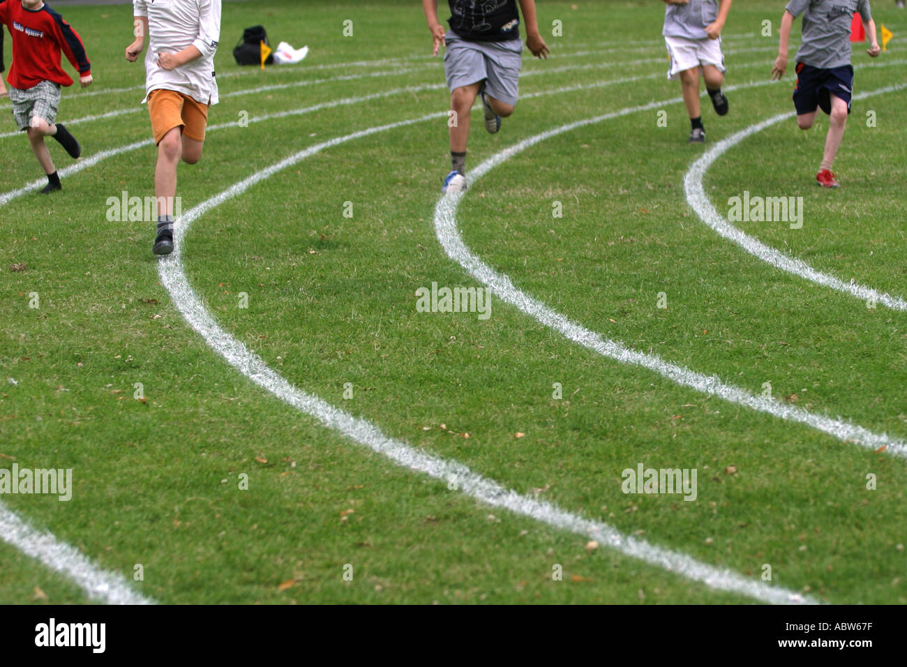 Junior school boys running during a race at their school sports day, Clissold Park, London, UK