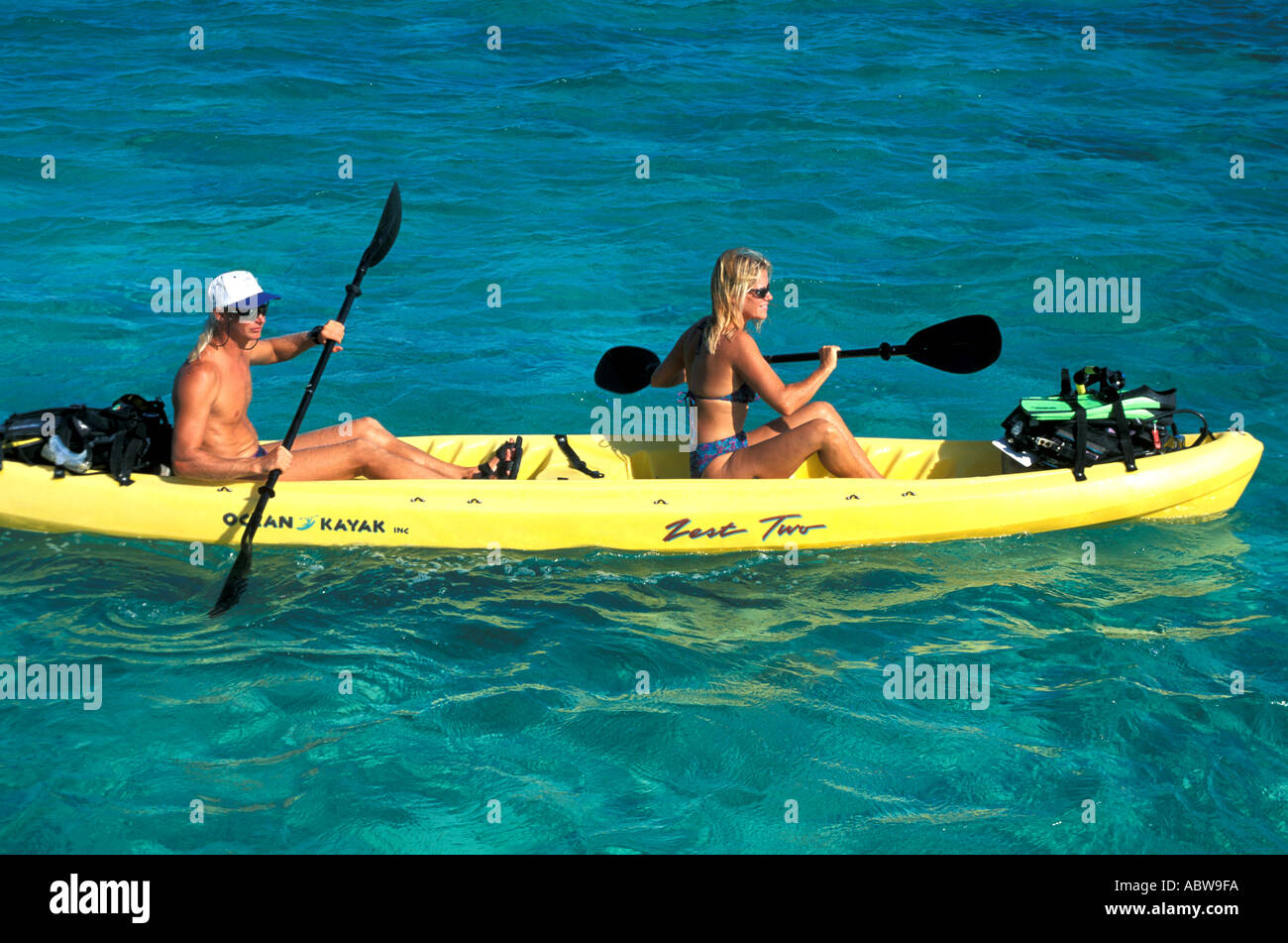 Scuba Diving Kayaking couple in yellow kayak with full scuba gear Stock