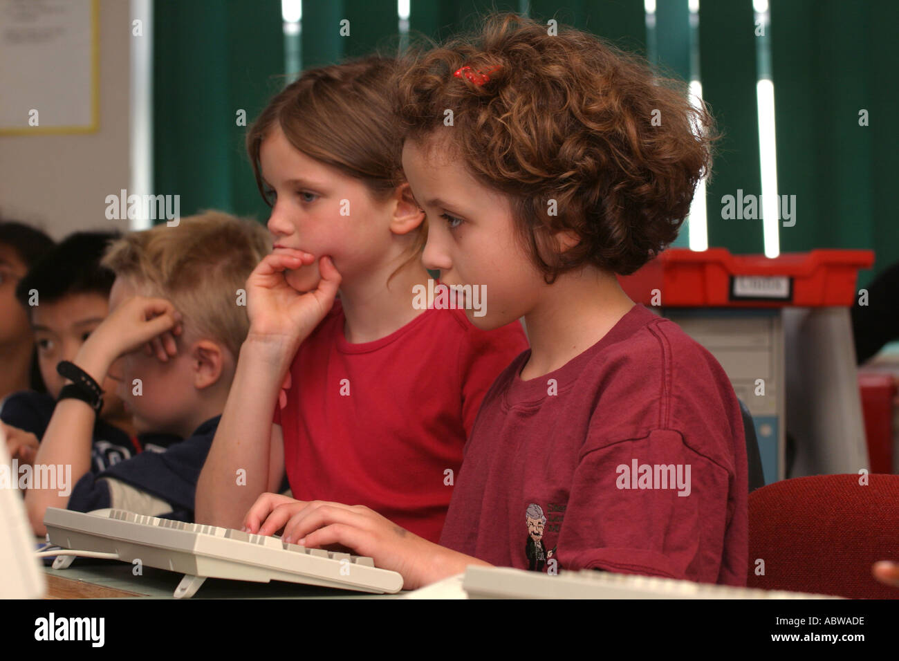 Two girls working on computers at their school computer suite, Betty Layward junior school, London, UK. Stock Photo