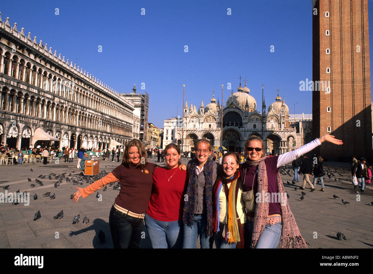 Group of colege girl tourists brightly dressed in front of the Famous St Marks Church in San Marcos Plaza in romantic Venice Ita Stock Photo