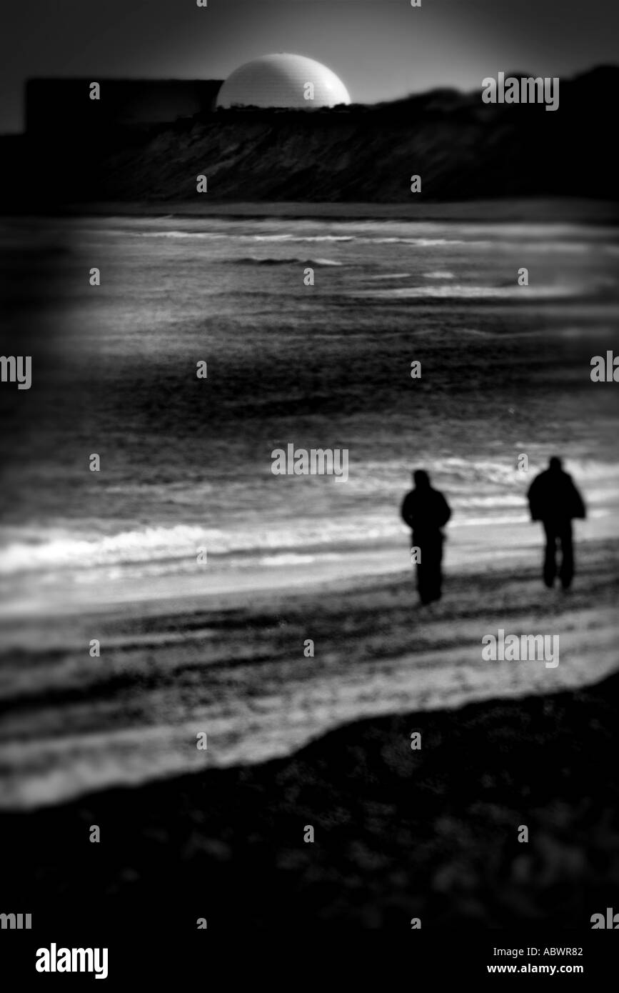 couple walking on Dunwich beach near Sizewell Nuclear power station Stock Photo