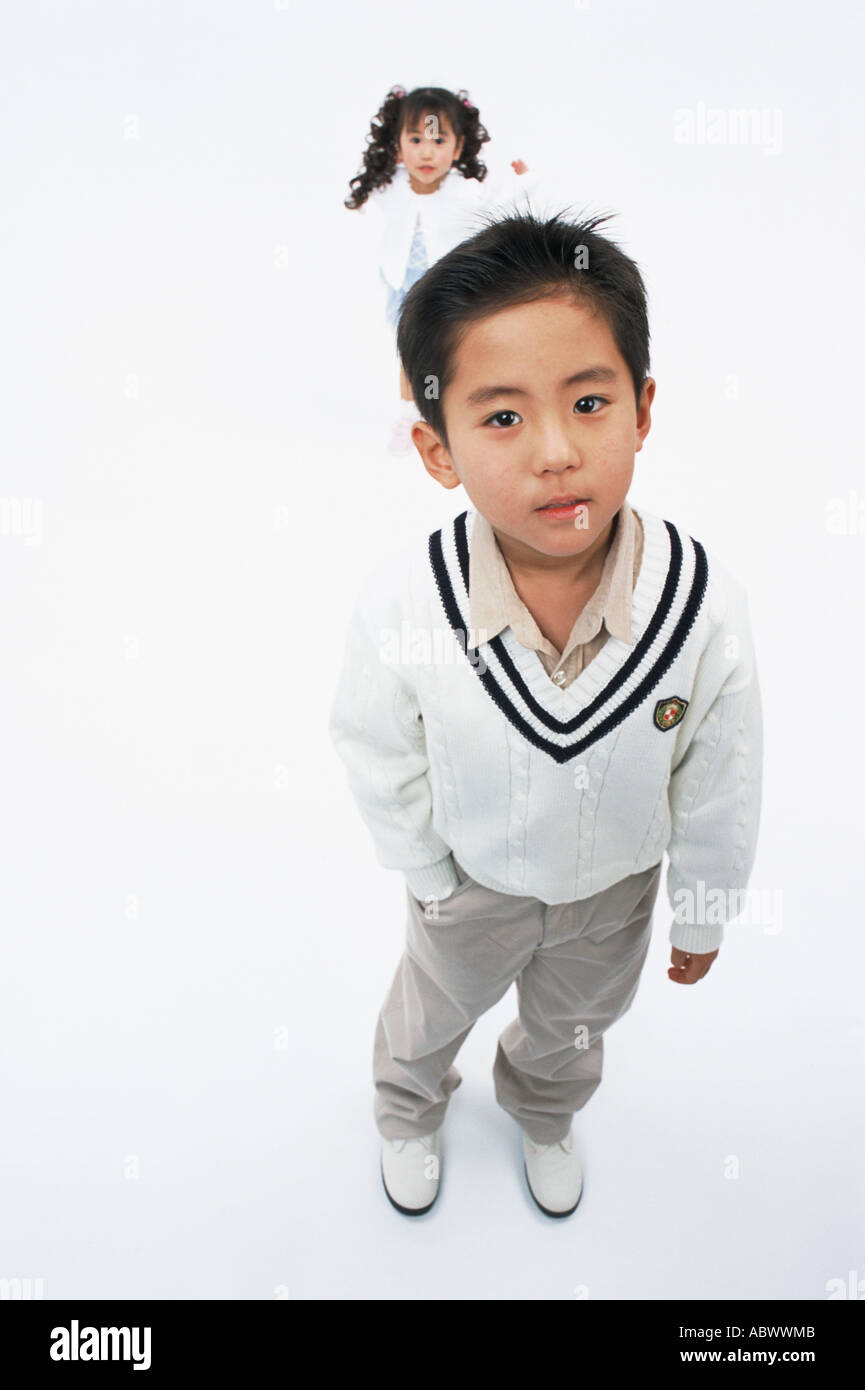 A boy looking at camera while a girl stands behind Stock Photo - Alamy