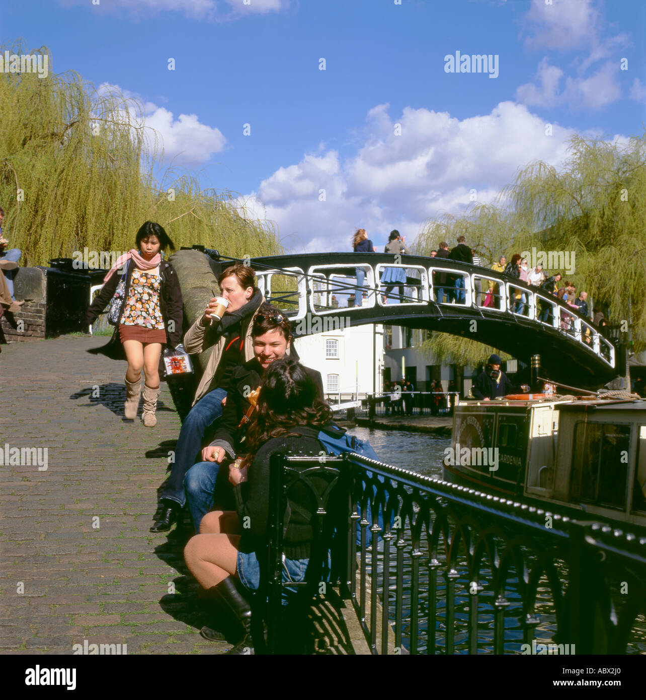 People relaxing by the footbridge at Regents Canal Camden Lock London UK Stock Photo