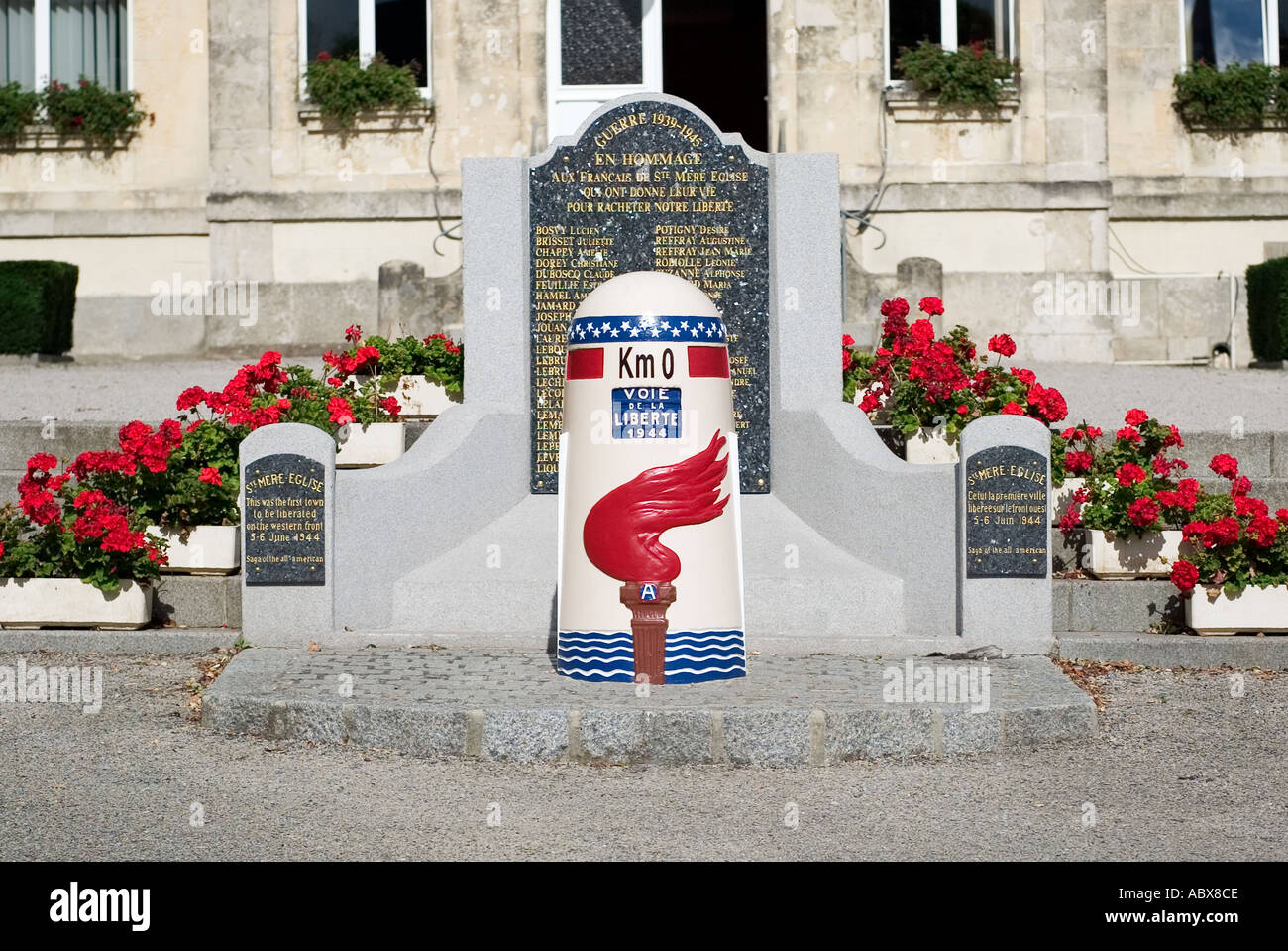 Start of the WW2 Route de la Liberation. Memorial Liberation Stone at Km0 marker outside the Town Hall in St Mere Eglise, Normandy, France Stock Photo