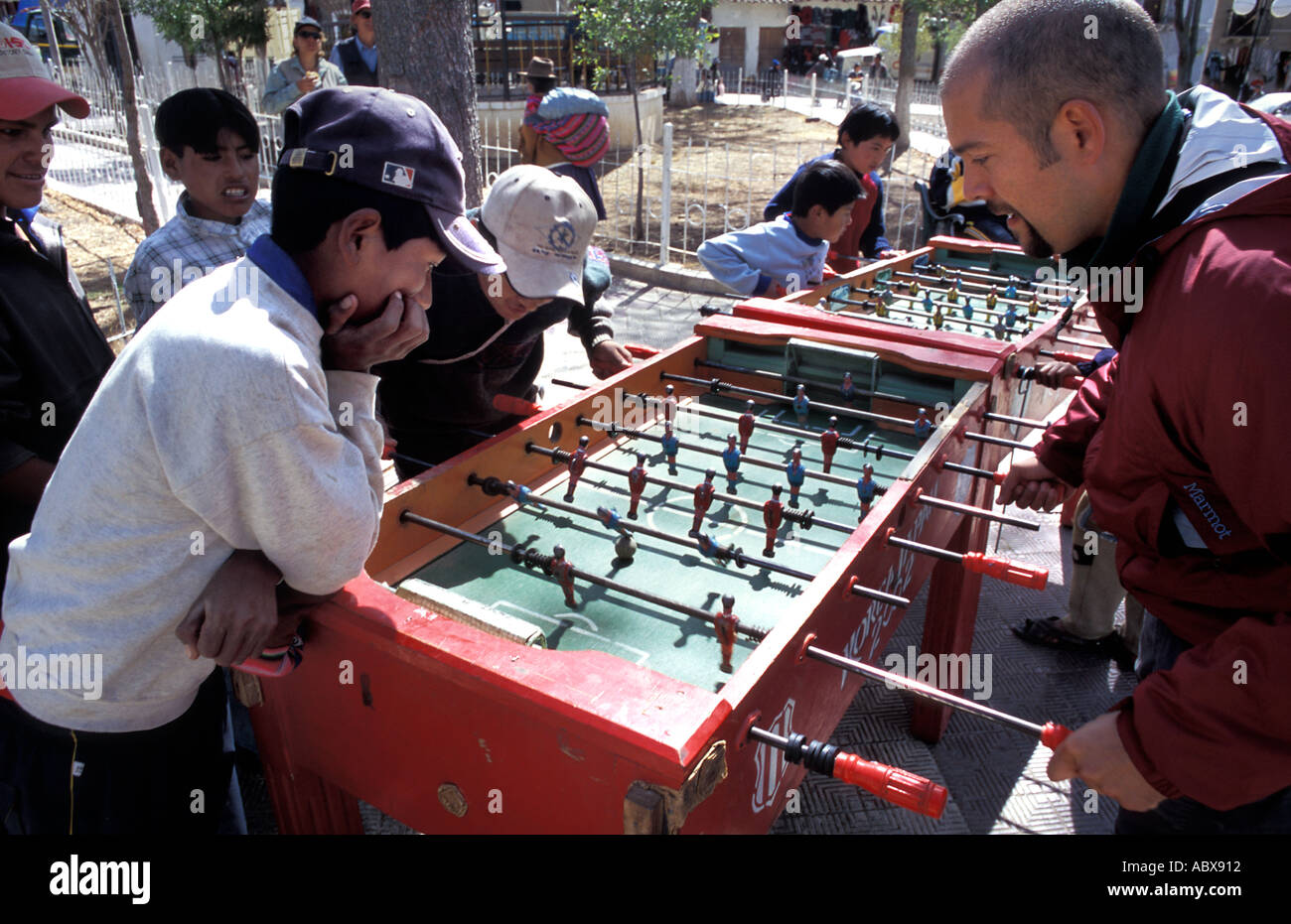 Traveller and Bolivian boys playing table football in the plaza