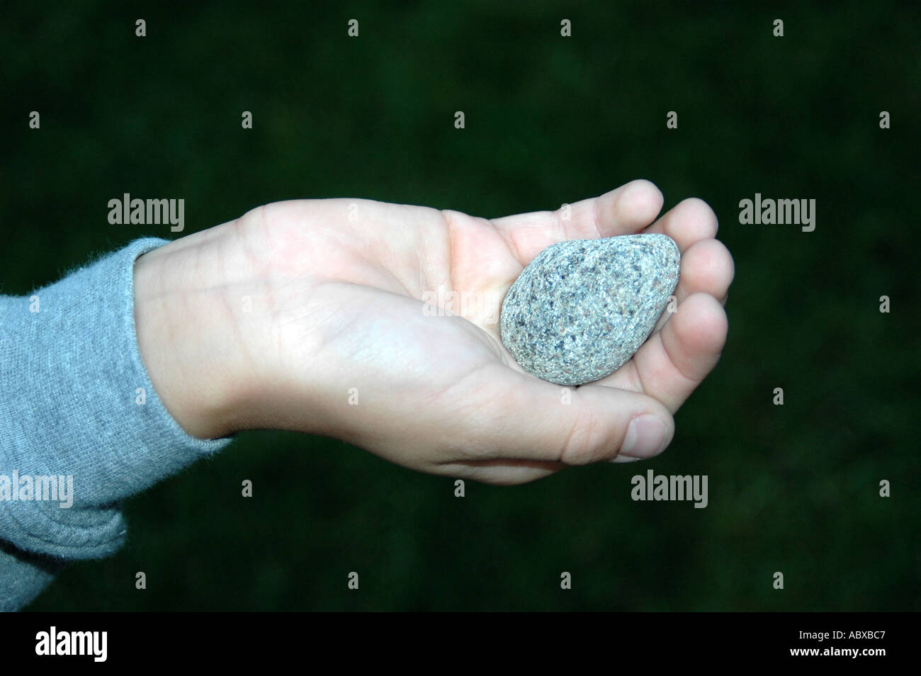 Hand holding stone talisman Stock Photo - Alamy