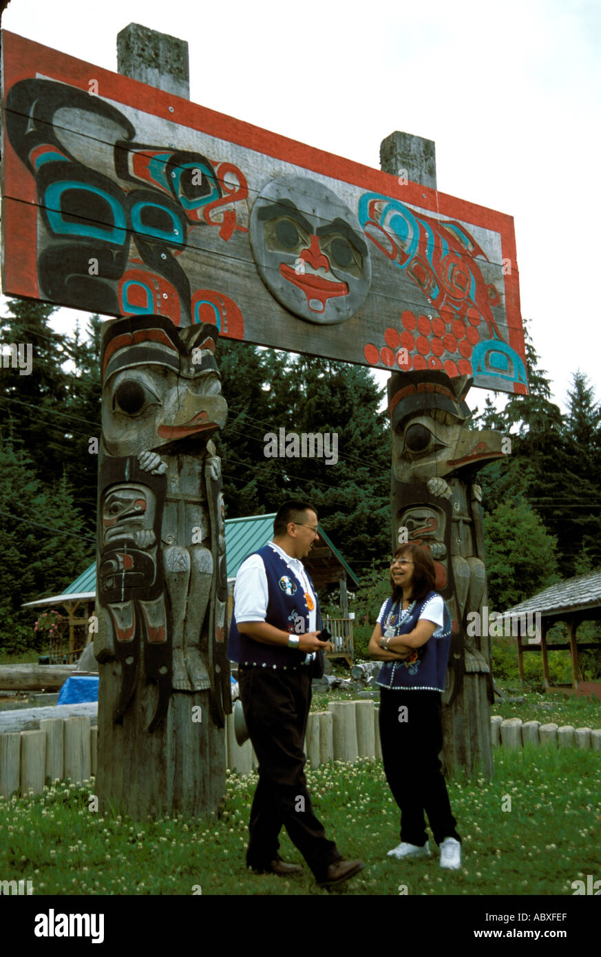 Totem poles and Tlingit Indians  in the Tlingit Indian village of Alaska AK Stock Photo
