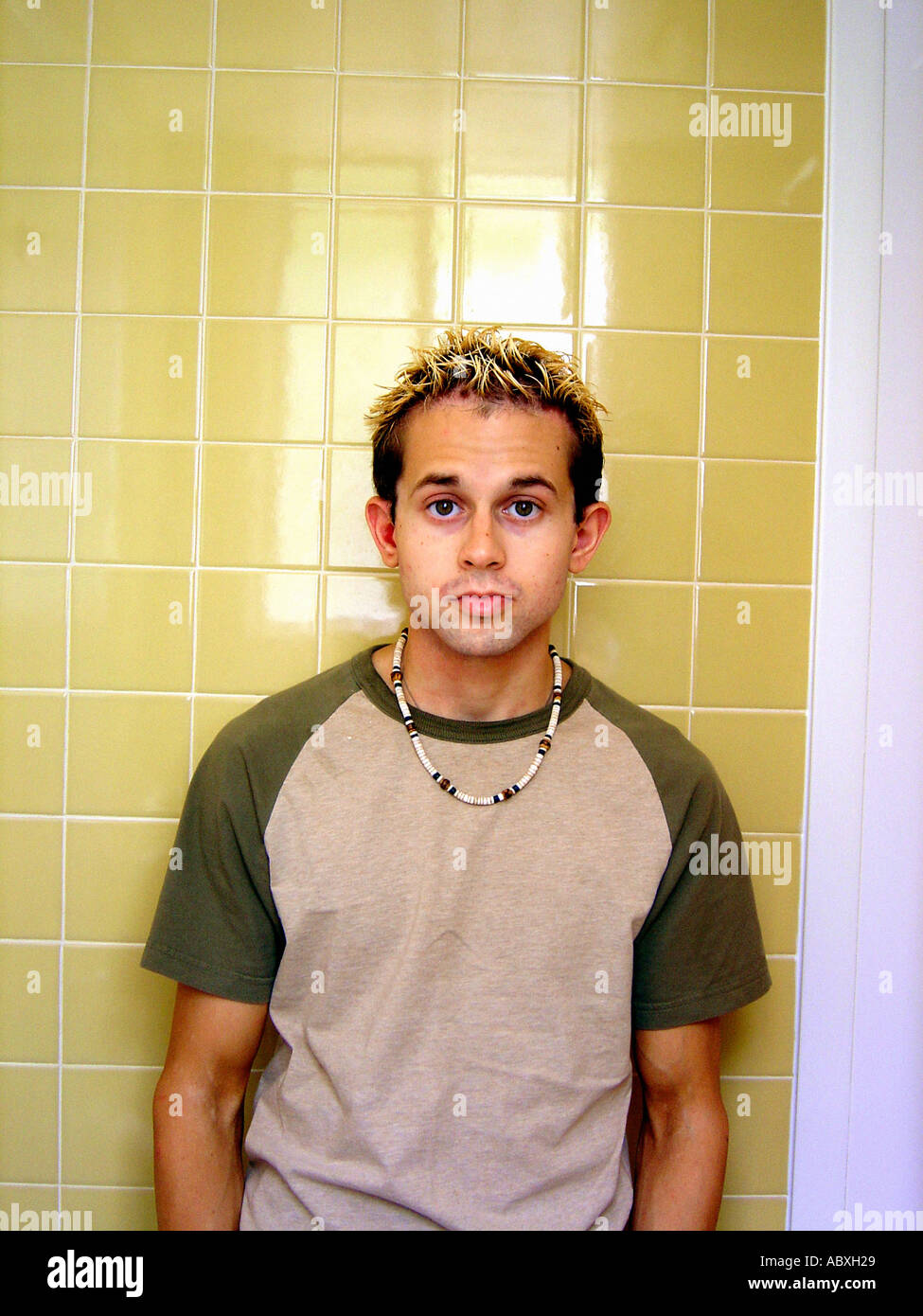 Portrait of a Young Man Standing in Front of a Yellow Tiled Wall Stock ...