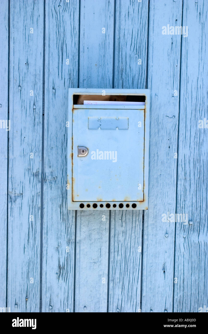 private home blue azur box letter on a old wooden door with letter inside in France street charente maritimes village Stock Photo