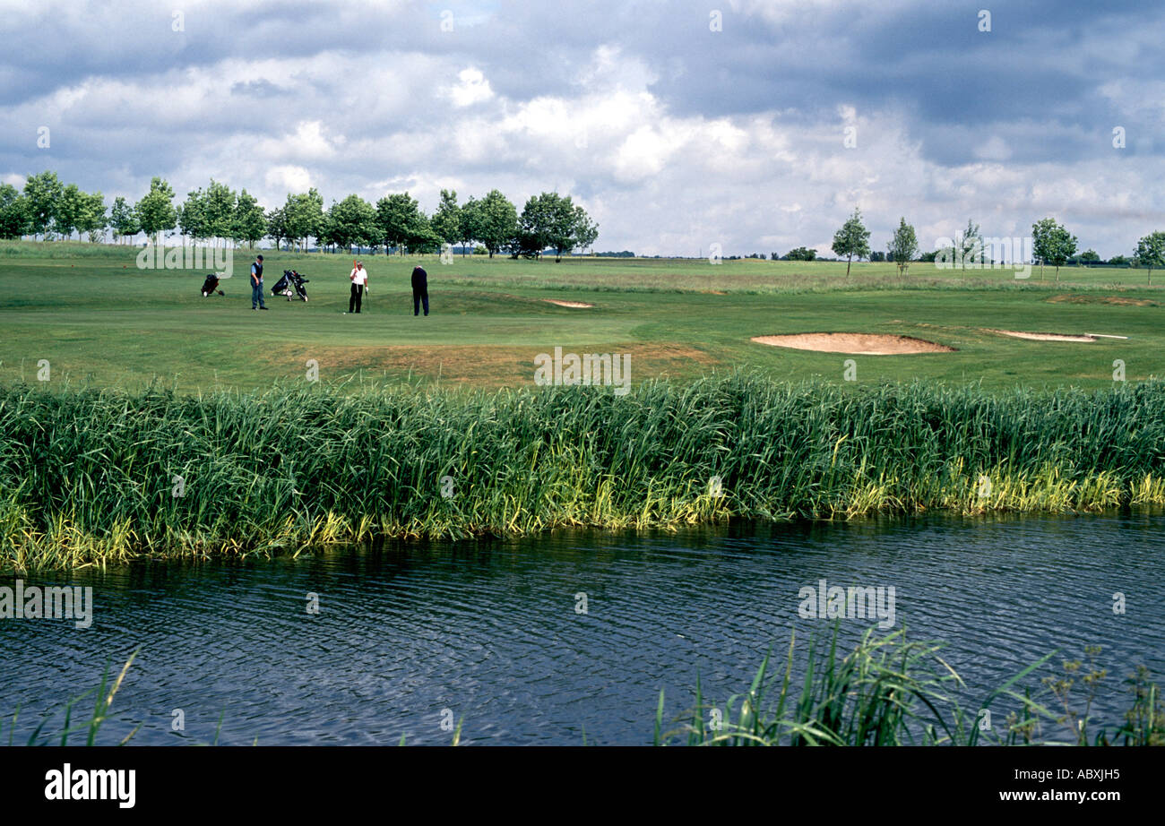 three golfers on putting green on golf course beside canal Bridgwater