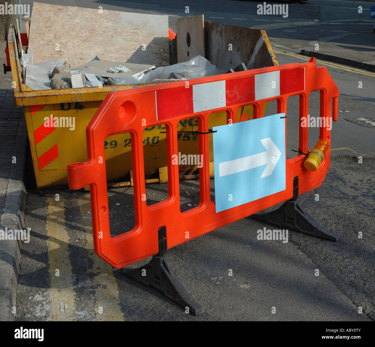 Road sign evading a skip Stock Photo Alamy