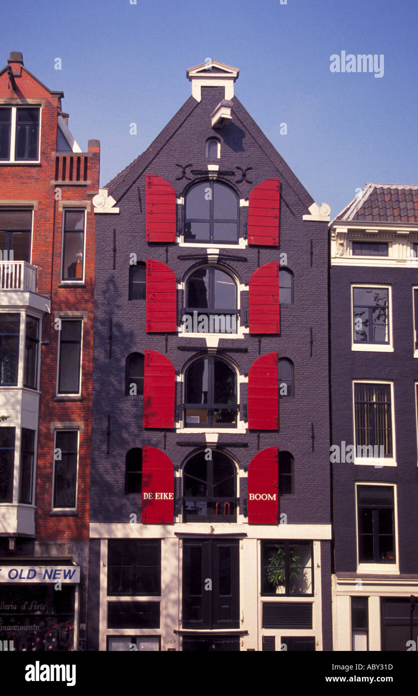 House with red shutters along a canal in Amsterdam Stock Photo