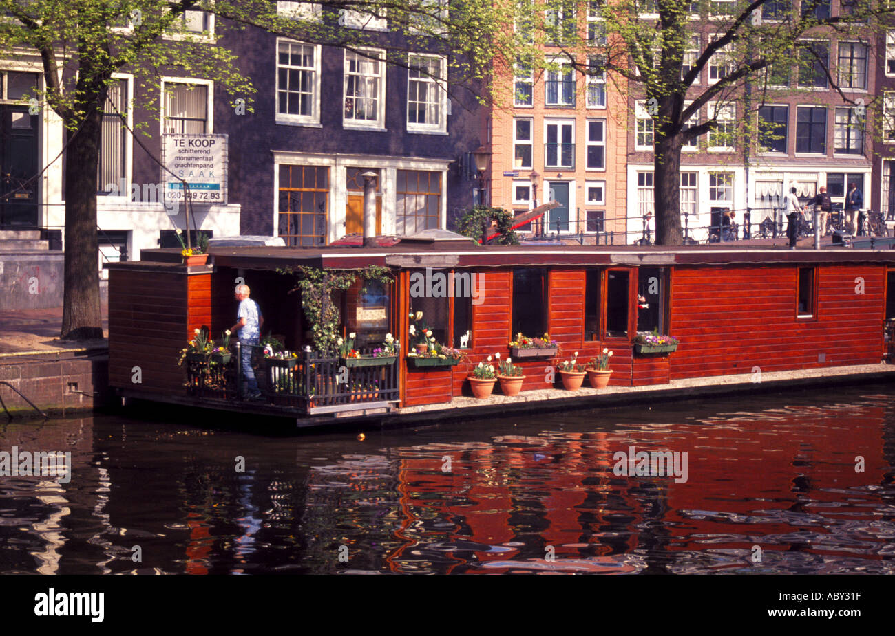Houseboat with flower boxes on a canal in Amsterdam Stock Photo