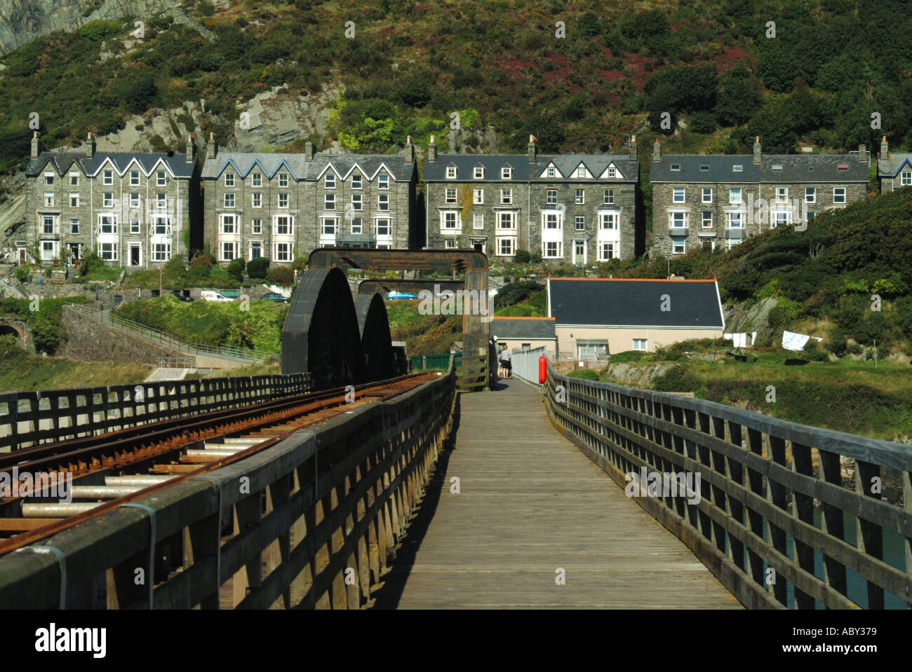 Barmouth Afon Mawddach railway viaduct and toll footbridge providing walking cycling link with Fairbourne side of estuary Stock Photo