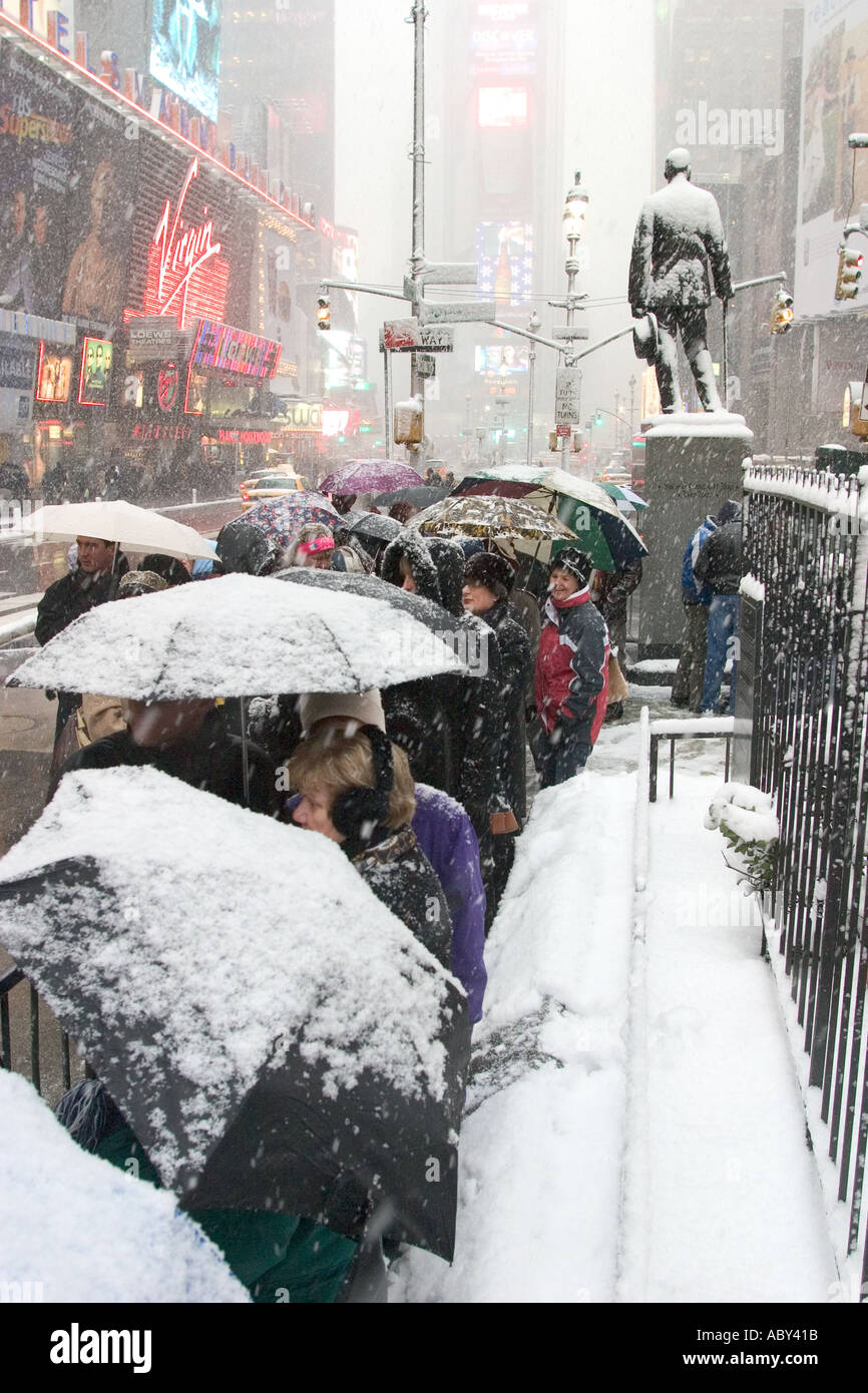 Theatre goers seeking discount tickets TCKTS wait in a snowstorm at 47th Street in Times Square Stock Photo