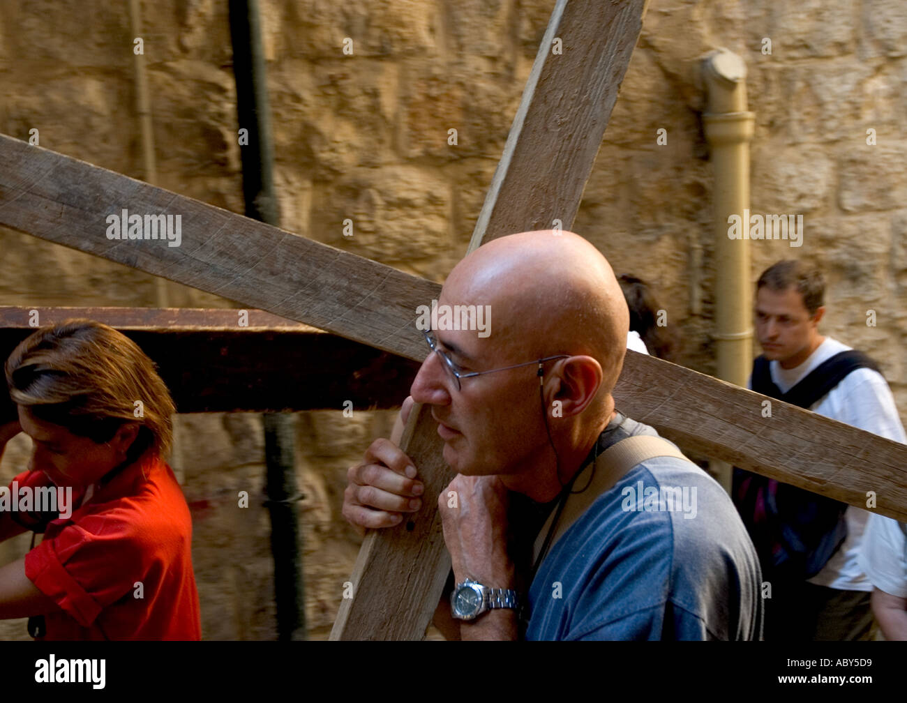 Israel Jerusalem old city Via Dolorosa way of the cross procession portrait of a pilgrim walking up with a cross on the shoulder Stock Photo