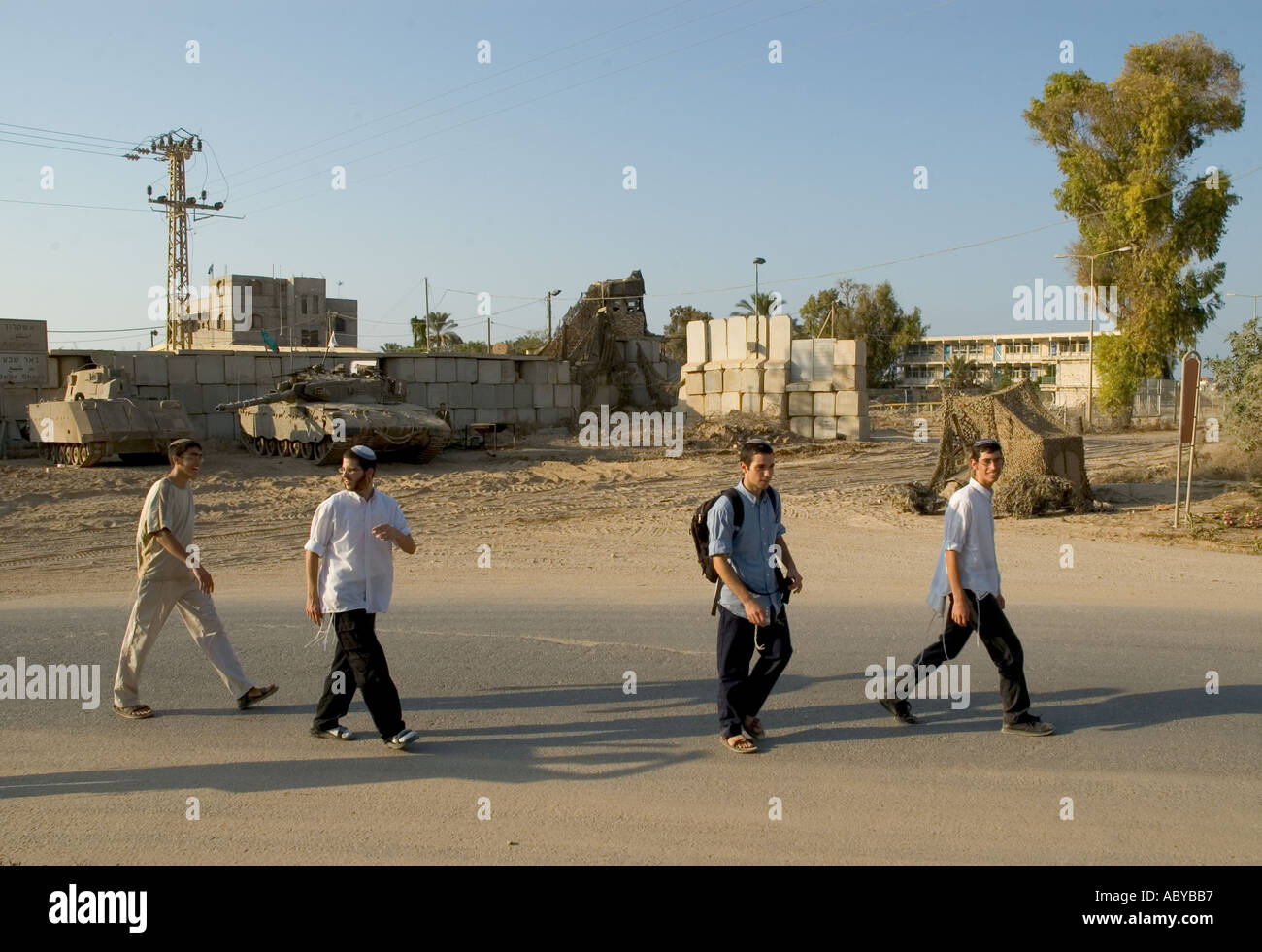 Isarel Gaza strip Gush Katif settlements Kfar Darom youngsters walking passed army vehicles Stock Photo