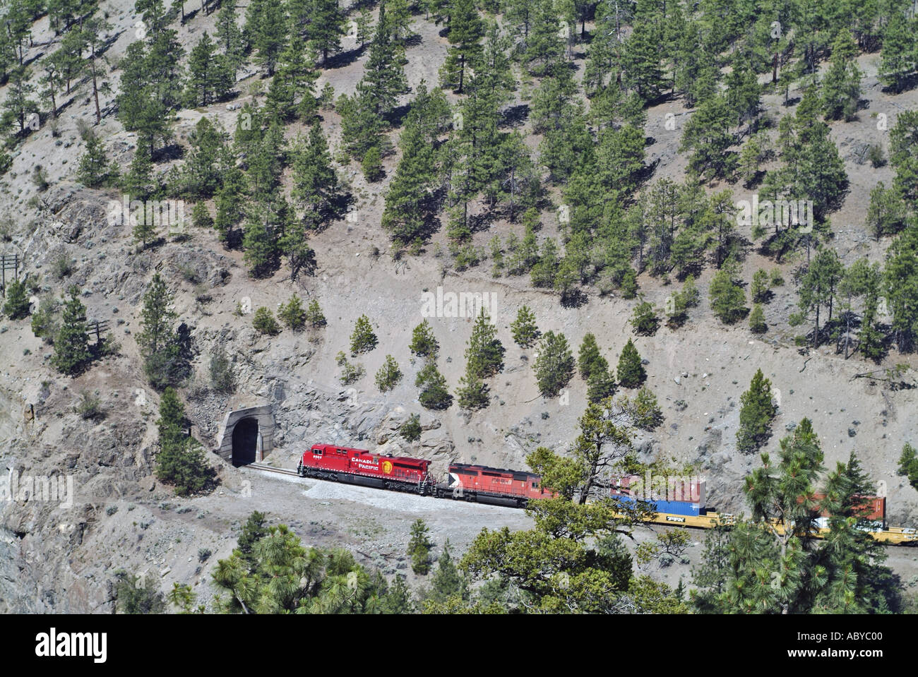 Freight train travelling through tunnel in mountain pass Thompson Stock