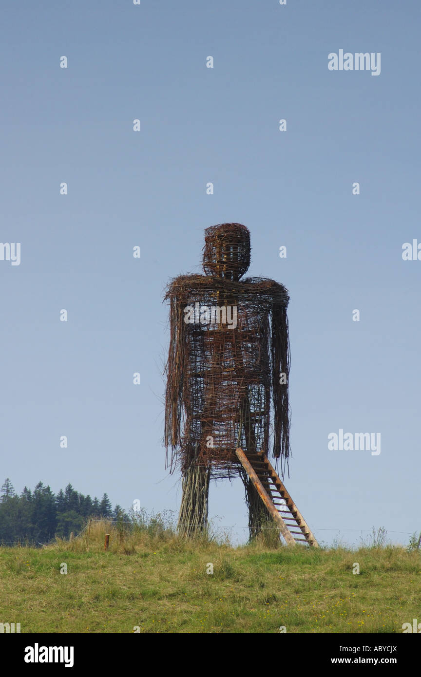 A giant wicker man stands on a ridge Space for text in the clear blue sky Stock Photo