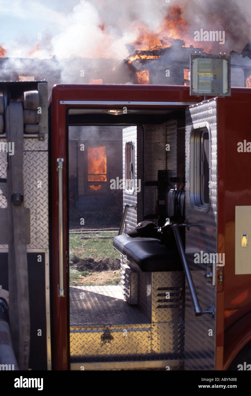 Fire truck at a scene of a house fire viewed through an engine Stock Photo