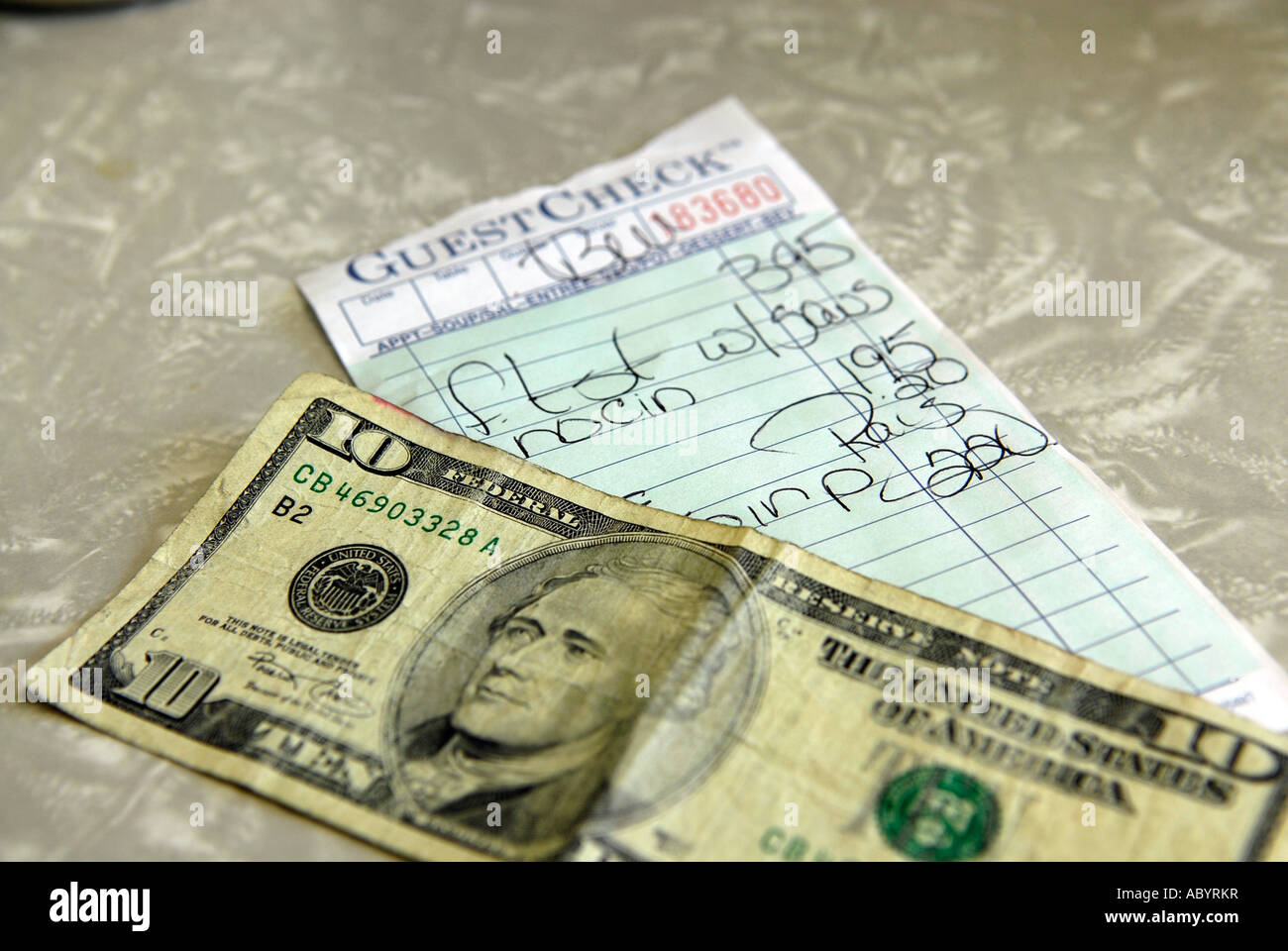10 dollar bill on the table in preparation of paying a bill for food in a short order restaurant Stock Photo