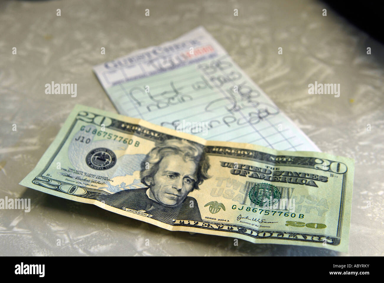 20 dollar bill on the table in preparation of paying a bill for food in a short order restaurant Stock Photo