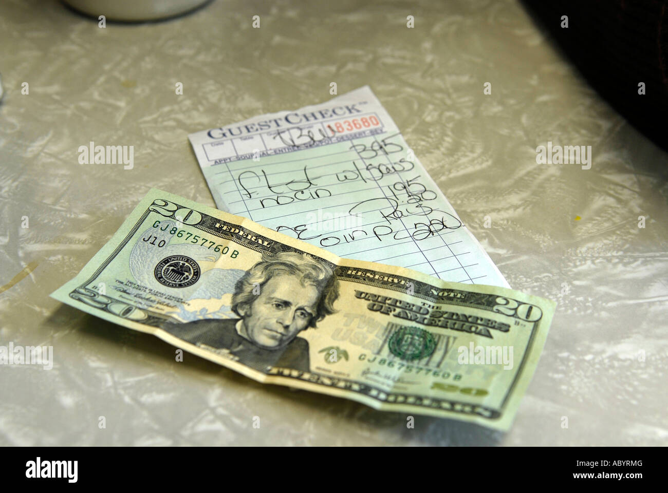 20 dollar bill on the table in preparation of paying a bill for food in a short order restaurant Stock Photo