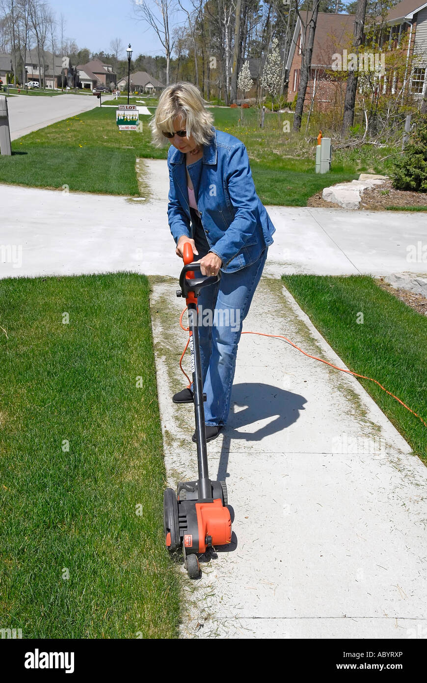 Adult female uses power electrical edging tool to enhance the