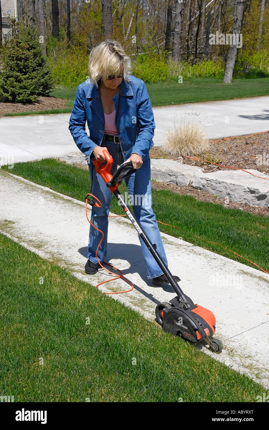 Adult female uses power electrical edging tool to enhance the