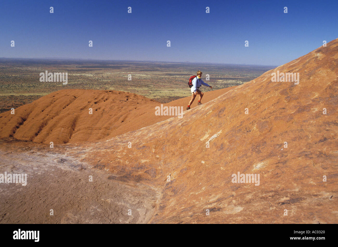 Woman climbing Ayers Rock Australia Stock Photo Alamy