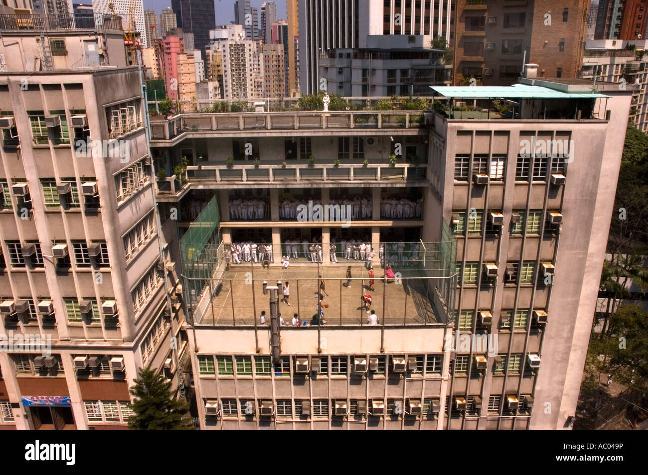 School with boys playing basketball on a highrise court on the crowded island of Hong Kong. 2006 Stock Photo