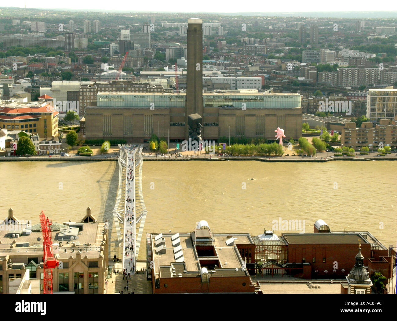 day Millenium bridge crossing the River Thames with the Tate Modern art gallery opposite London England Stock Photo