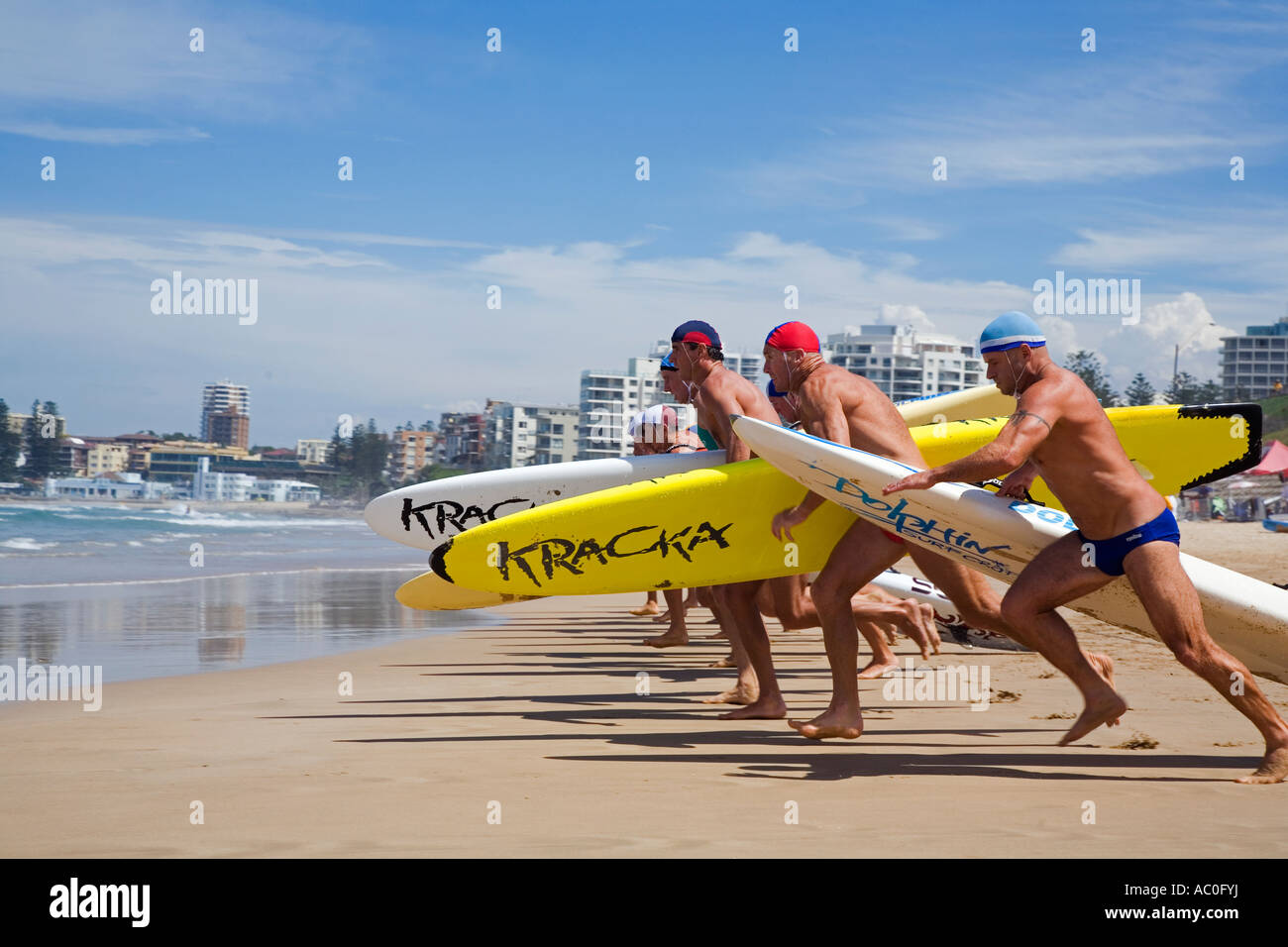 Competitors run for the water with rescue boards under their arms during a race on Cronulla Beach Stock Photo