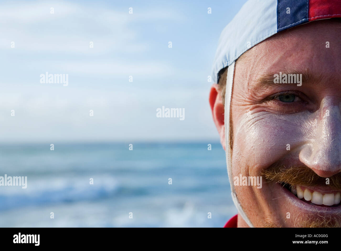 The face of a surf lifesaver wearing a traditional patrol cap at Cronulla Beach in Sydney Stock Photo