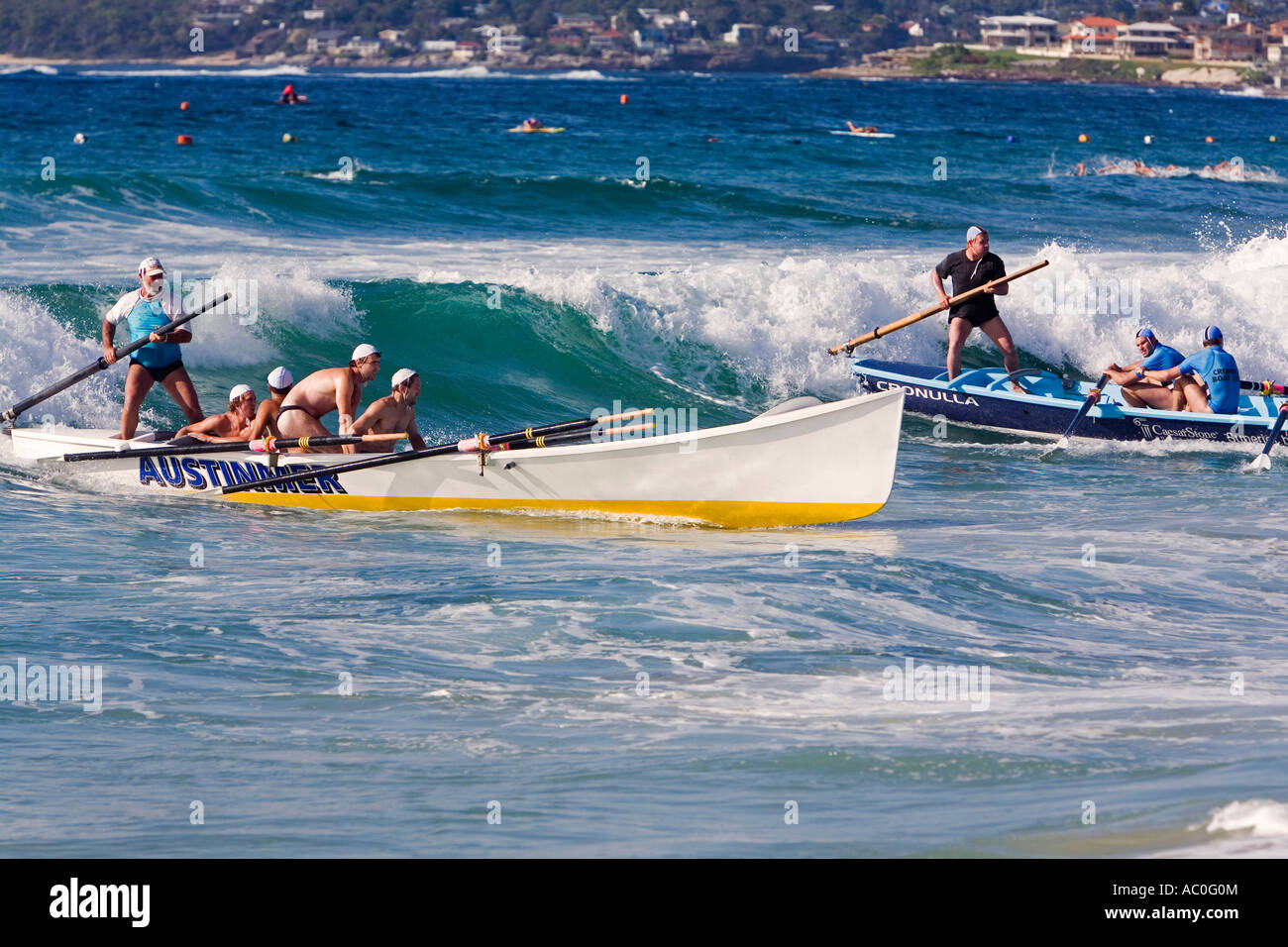 Surfboat crews ride the waves into shore during the New South Wales Surf Lifesaving Carnival at Cronulla Beach Stock Photo