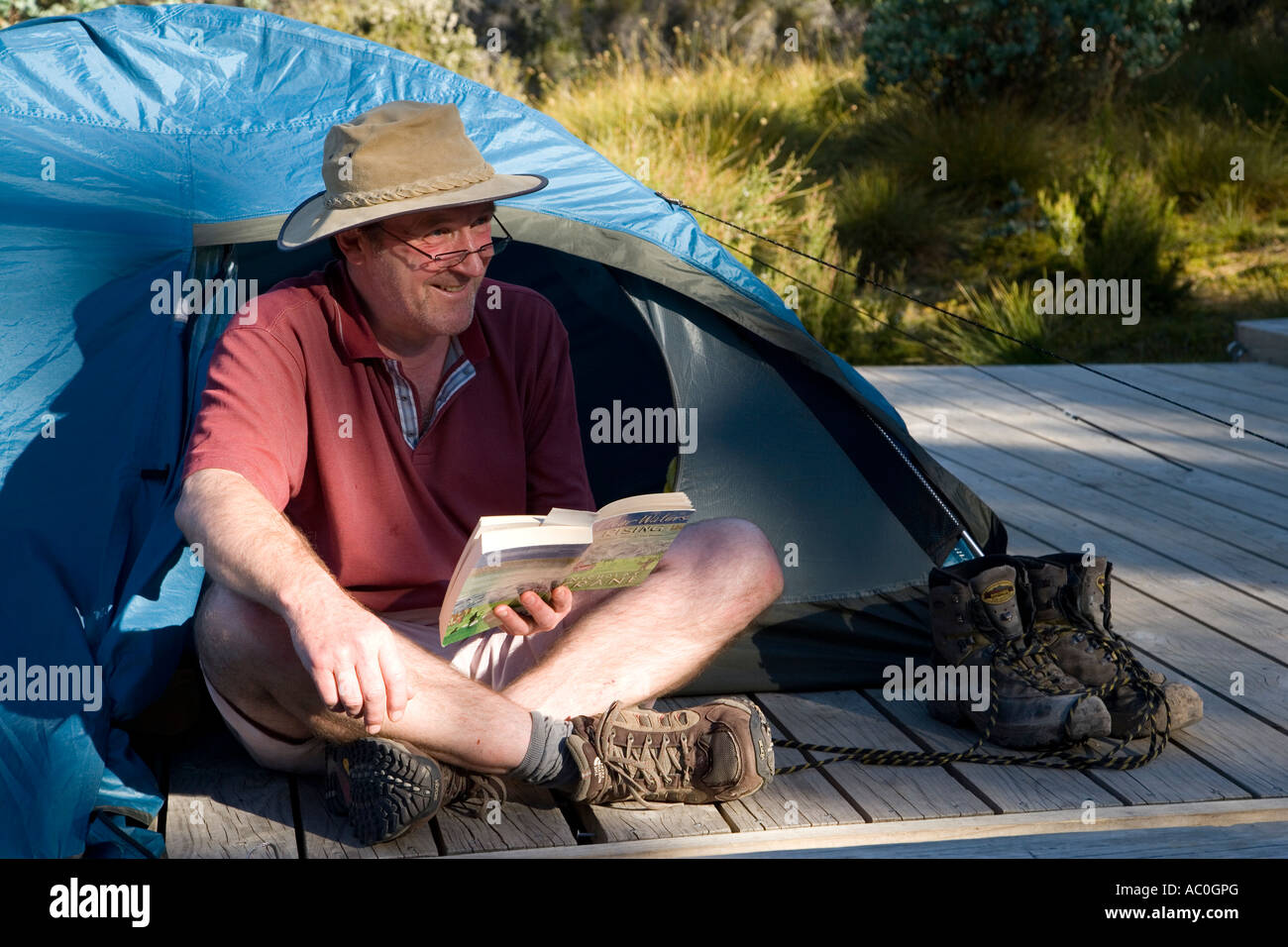 A trekker relaxing at camp after a hard day hiking on the Overland Track Stock Photo