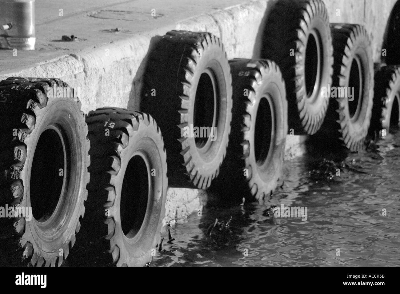 Large tires tyres arranged as fenders at dock on Robben Island Cape Town South Africa Stock