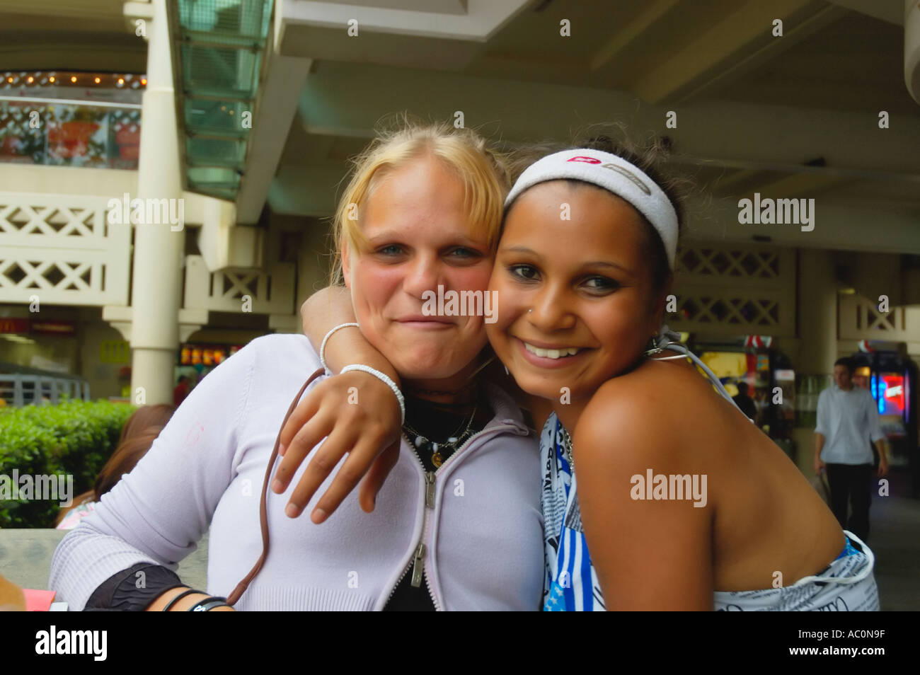 Western Australia Perth Young smiling Aboriginal girl embracing her white  friend Stock Photo - Alamy