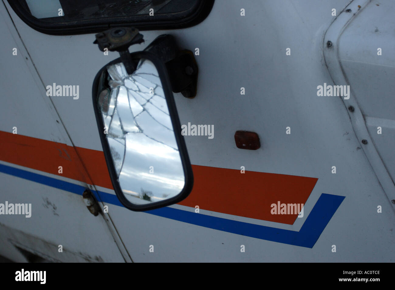 Cracked wing mirror of bus dumped on the side of the road Stock Photo