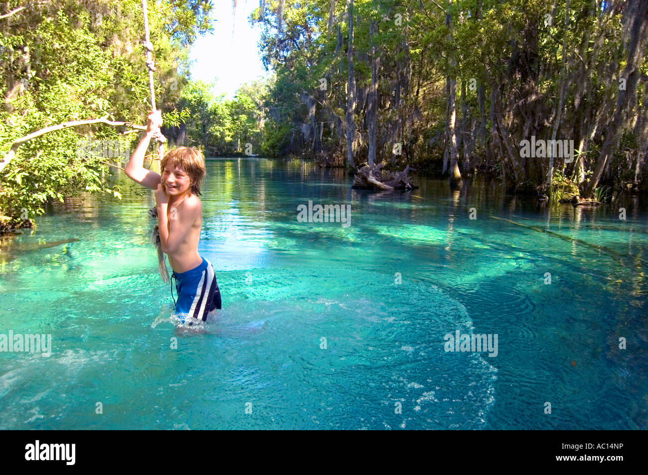 Boy hanging from a rope swing Three Sisters Spring Crystal River