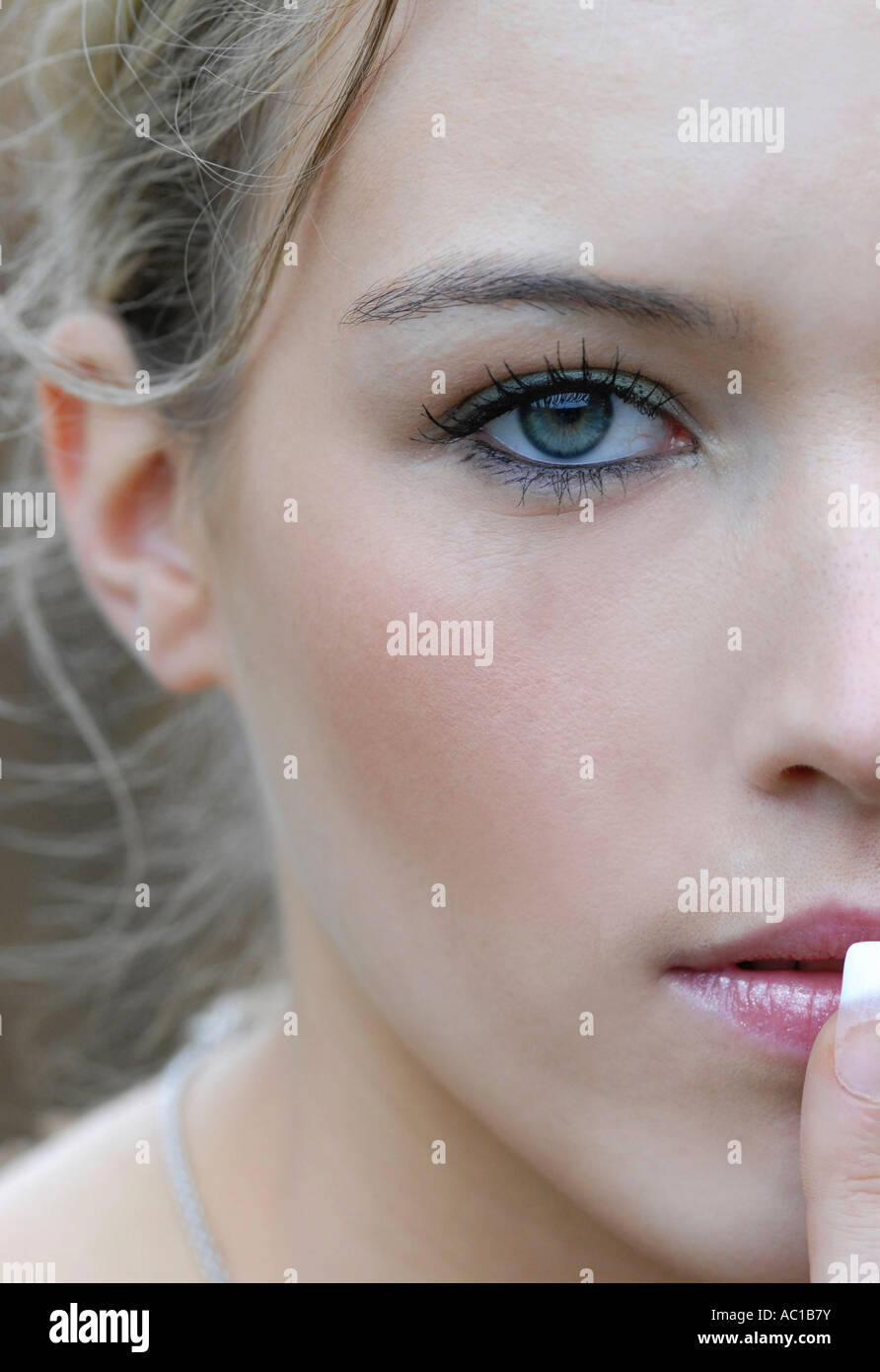 Young woman holding finger to lips portrait close up Stock Photo - Alamy