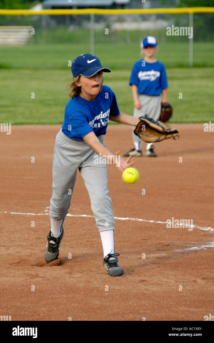 Female girl Little League baseball pitcher player throwing a baseball