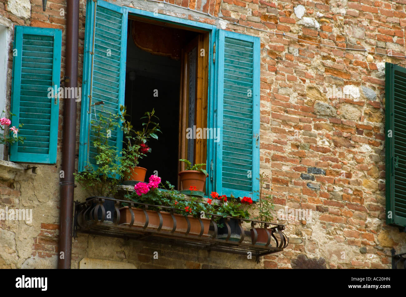 Window with teal shutters in a village in the Tuscany region of Italy Stock Photo